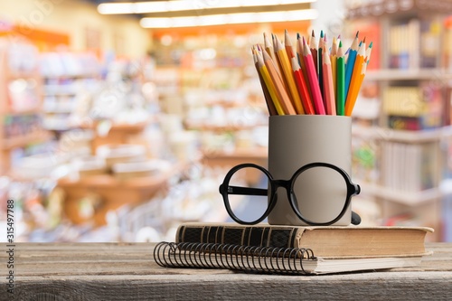 School stack old vintage books with glass and colorful pencil