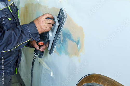 Car mechanic painted the car body close-up