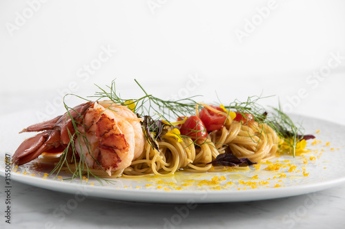 Housemade lobster pasta with cherry tomatos, garlic, dill and lemon zest photo