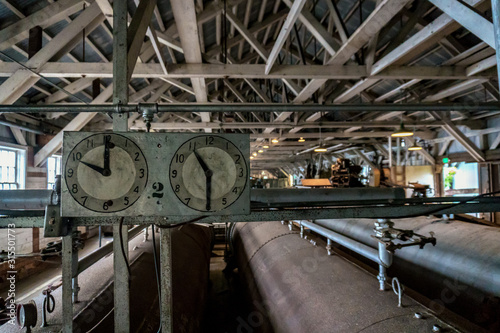 Tableau sur toile Old abandoned cannery. Two clocks are in the empty factory.