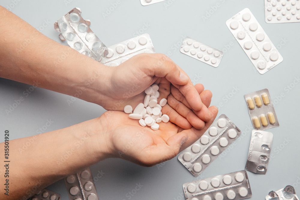 Obraz premium Medication and white pills in the hand. View from above