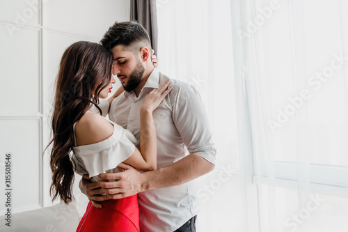 boyfriend kisses girlfriend at home in apartment
