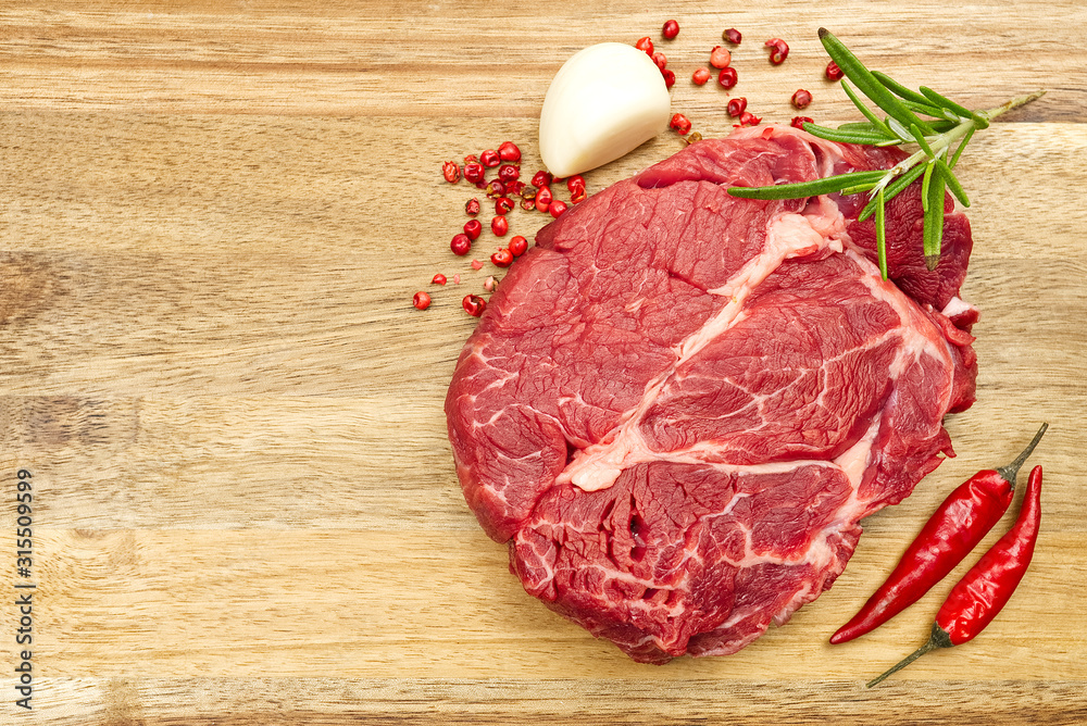 Raw beef steaks on wood board view from above. fresh steak with spices ready for cooking. Raw beef steaks on wood board view from above. fresh steak with spices ready for cooking.