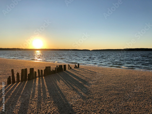 Sunset over Hobart Beach Park with remnants of a wood fence in Northport, Long Island, New York. photo