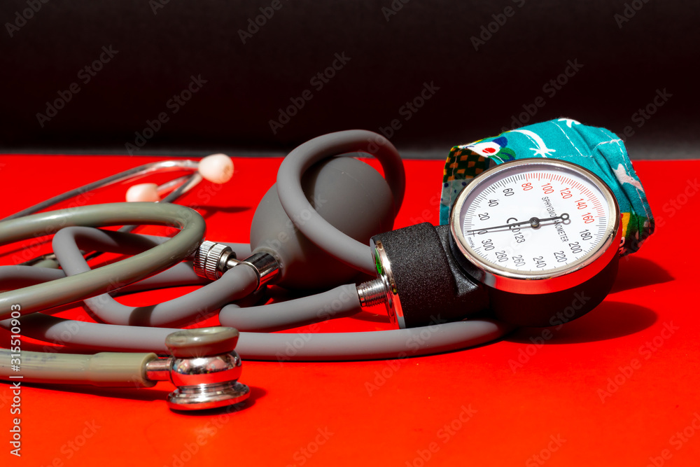 Neonatal stethoscope and Pediatrics sphygmomanometer on red with black