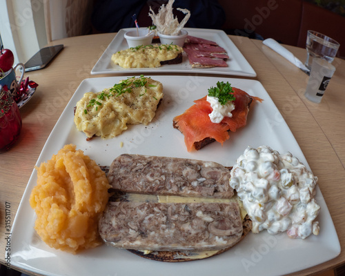 Icelandic food sample platter with sheep head jelly, trout, bean salad, mashed fish and turnips