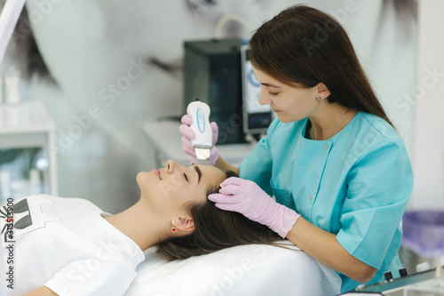 Female at cosmetic beauty spa clinic has facial hardware cosmetology. Woman making beauty procedures