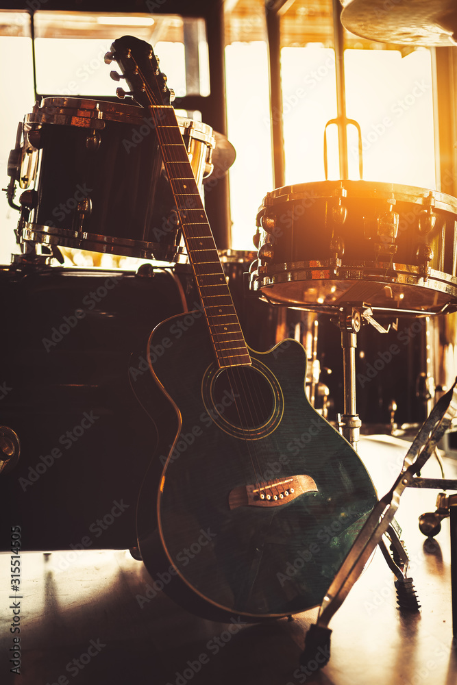 Fototapeta premium Guitar sitting on the ground and sun light at music studio.