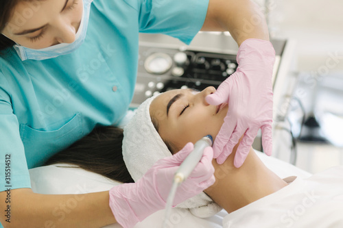 Close-up of woman getting facial hydro microdermabrasion peeling treatment. Female at cosmetic beauty spa slinic. Hydra vacuum cleaner. Cosmetology