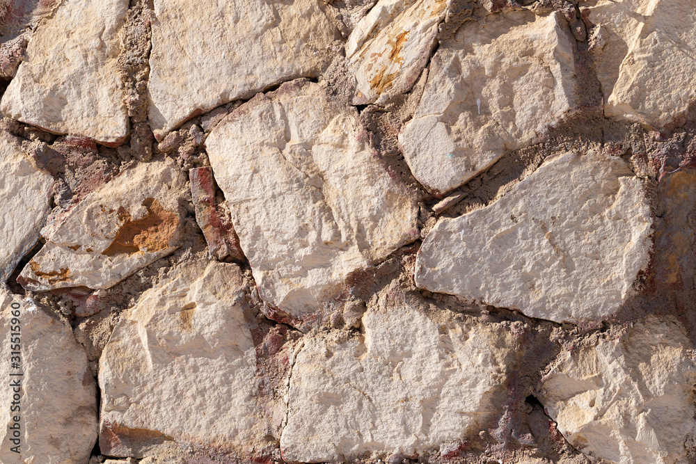Fototapeta premium Background of limestone masonry. The surface is decorated with natural material. The wall is made of wild stone.