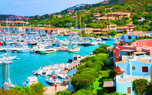 Scenery with Marina and luxury yachts at Mediterranean Sea of Porto Cervo in Sardinia Island of Italy in summer. Landscape View on Sardinian town port with ships and boats in Sardegna. Mixed media. photo