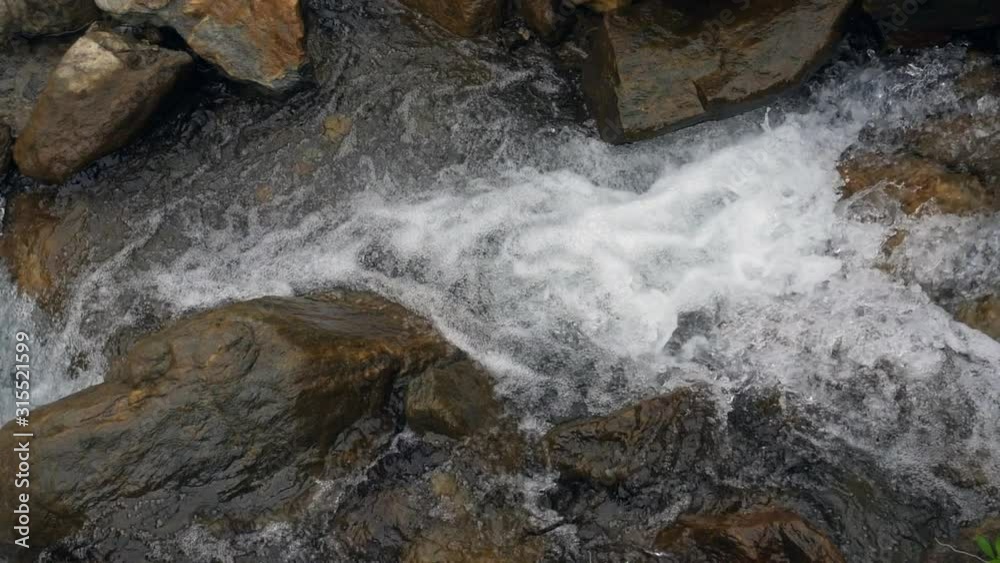 Clear water cascading among boulders in a steep rocky stream bed. On the Amazonian slopes of the Andes near the town of Banos, Tungurahua province, Ecuador. Clear water cascading among boulders in a steep rocky stream bed. On the Amazonian slopes of the Andes near the town of Banos, Tungurahua province, Ecuador.
