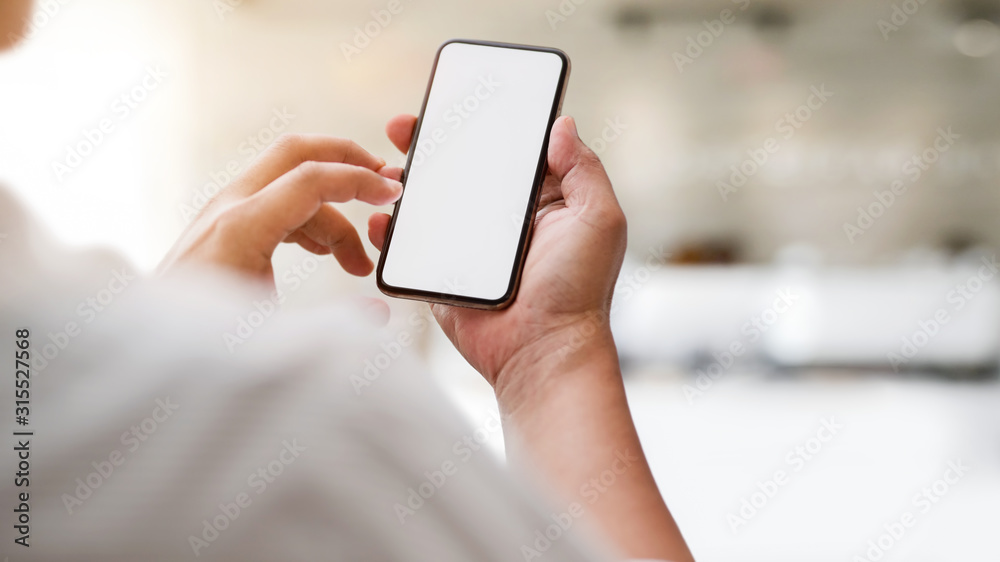 Cropped shot of typing  blank screen smartphone with blurred office room