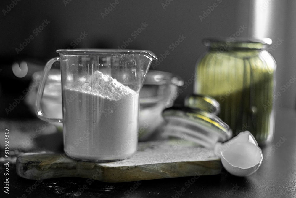 Ingredients for home baking: cookies, bread, cake. Flour, sugar, and eggs are on the black table. Baking dishes. Ingredients for home baking: cookies, bread, cake. Flour, sugar, and eggs are on the black table. Baking dishes.