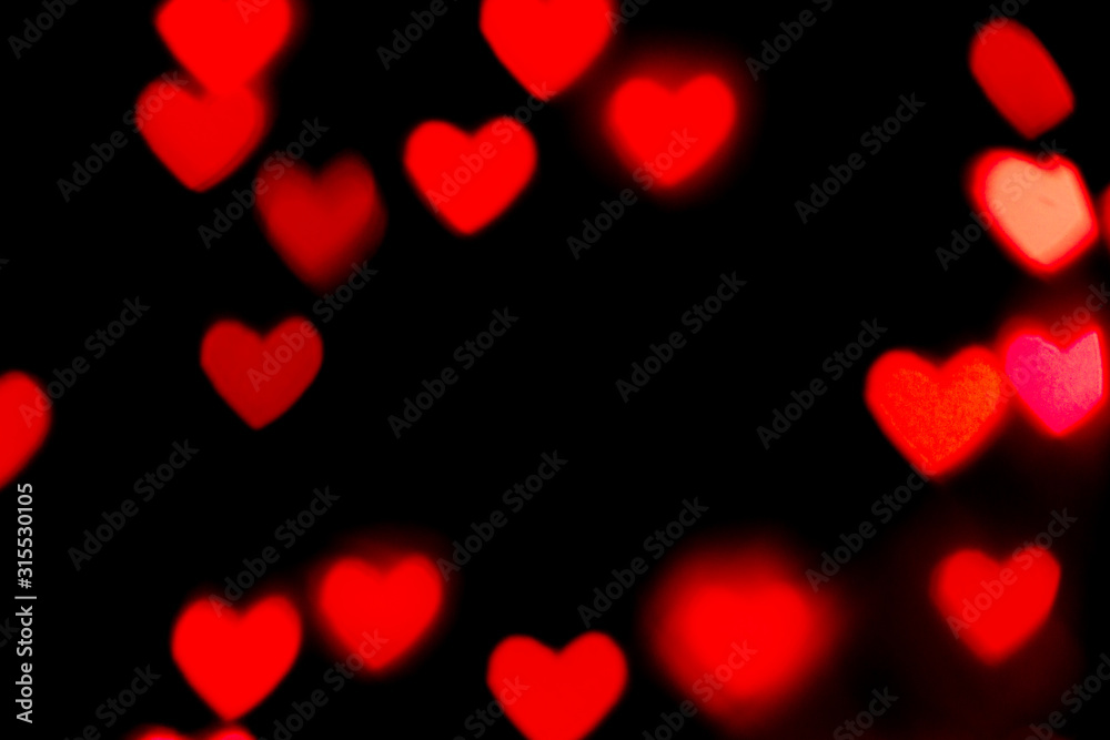 Black background with bright red warm heart shaped bokeh lights. Holiday, Valentines Day background. Ideal to layer with any design. Horizontal