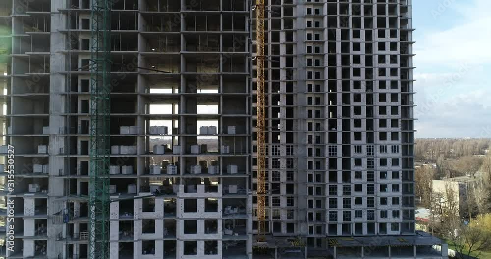 Aerial view on construction of multi-storey residential building in the city. Construction site of high-rise building. Foundation of multi-storey building. Residential building under construction Aerial view on construction of multi-storey residential building in the city. Construction site of high-rise building. Foundation of multi-storey building. Residential building under construction