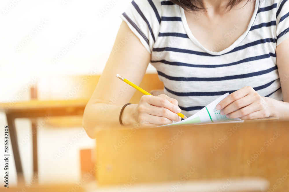 high school,university student study.hands holding pencil writing paper answer sheet.sitting lecture chair taking final exam attending in examination classroom.concept scholarship for education abroad high school,university student study.hands holding pencil writing paper answer sheet.sitting lecture chair taking final exam attending in examination classroom.concept scholarship for education abroad