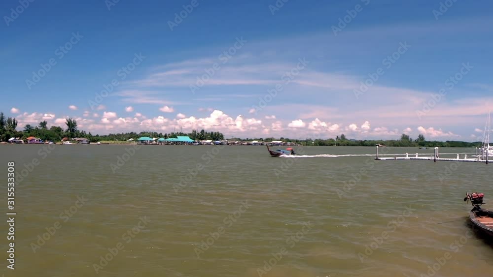 Standing and looking at a boat in the lake in Krabi (Thailand) Standing and looking at a boat in the lake in Krabi (Thailand)