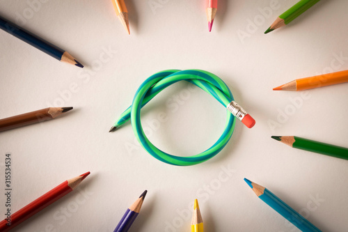 Colored pencils with one flexible pencil on white background. The concept of flexibility in decision-making.