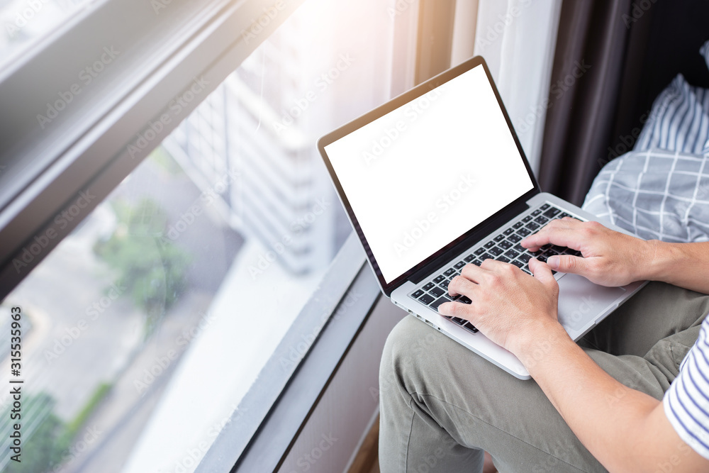 Fototapeta premium mockup image blank screen computer with white background for advertising text,hand man using laptop contact business search information at home office.marketing and creative design