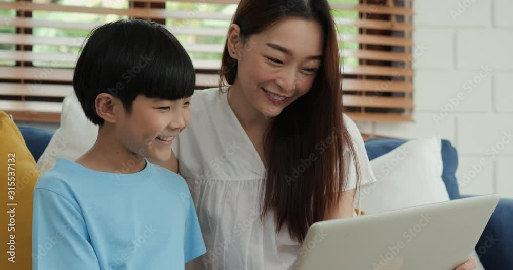 Mother and son using computer together at home with happy emotion. Family, Technology and Lifestyle concept. Mother and son using computer together at home with happy emotion. Family, Technology and Lifestyle concept.