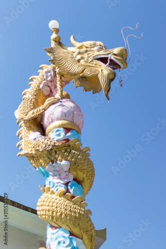 Golden dragon's head at the temple with blue sky background.