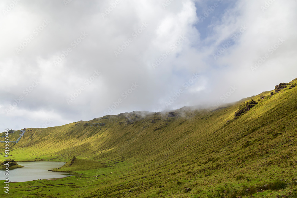Clouds linger around the northern rim of the Corvo Crater on the island of Corvo in the Azores, Portugal.