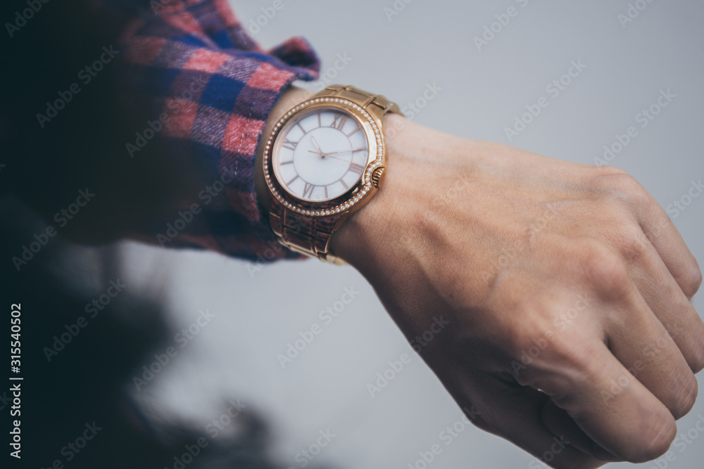 looking at luxury watch on hand check the time at workplace.concept for managing time organization working,punctuality,appointment.fashionable wearing stylish looking at luxury watch on hand check the time at workplace.concept for managing time organization working,punctuality,appointment.fashionable wearing stylish