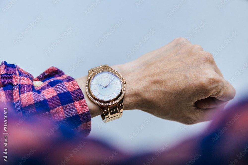 looking at luxury watch on hand check the time at workplace.concept for managing time organization working,punctuality,appointment.fashionable wearing stylish
