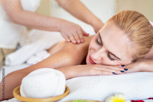 Beautiful young attractive Caucasian woman having body massage by Thai Masseur in spa salon. Beauty treatment and body care lifestyle concept.