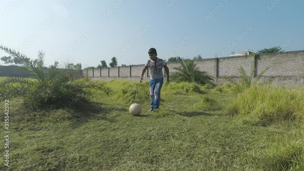 Indian boy kicks dribbles soccer ball, others take it away. Low, smooth action shot. 2x slow motion Indian boy kicks dribbles soccer ball, others take it away. Low, smooth action shot. 2x slow motion