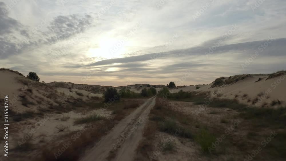 Aerial sunrise shot upon a desert offroad path 