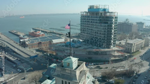 Aerial Drone Shot Orbiting an American Flag atop an old Staten Island Building