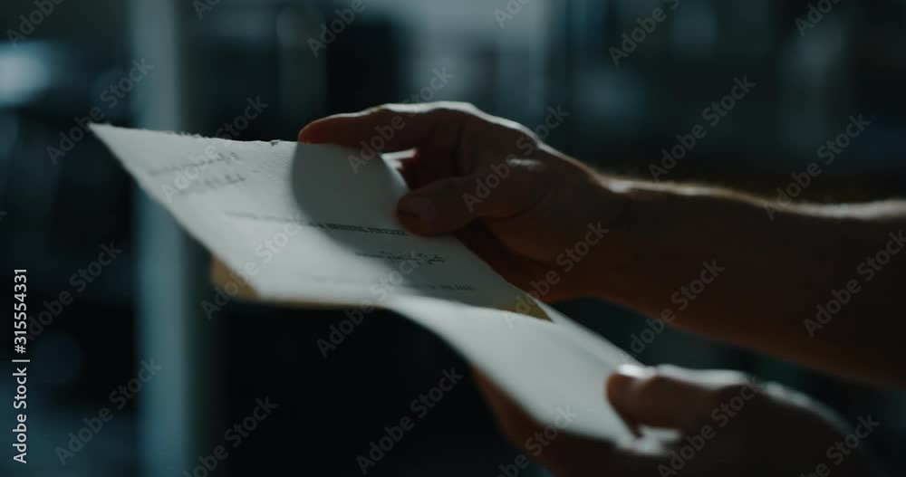 Cinematic close up shot of man is closing a letter before sending it. Concept of correspondence, calligraphy, communication