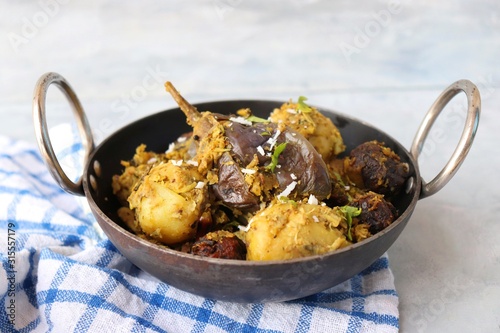 Food - Traditional Indian Gujarati dish Surti Undhiyu. Its a mixed vegetable dish cooked with stuffed brinjals, fried potatoes, Methi Muthia, purple yam, Papadi and spices. Makar Sankranti Special. photo