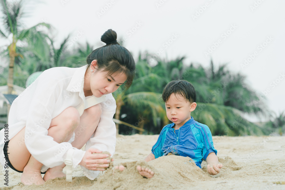 A mother is playing sand and swimming with her son on the beach. A mother is playing sand and swimming with her son on the beach.