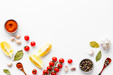Kitchen frame with spices and food - pepper, garlic, cherry tomatoes - on white background top-down frame copy space