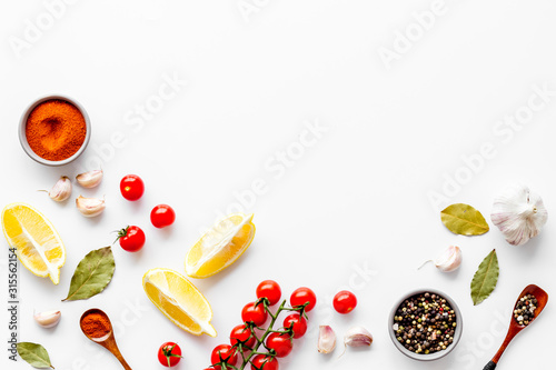фотографія Kitchen frame with spices and food - pepper, garlic, cherry tomatoes - on white