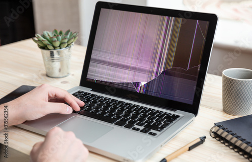 Obraz na płótnie Man working with a broken laptop computer on office business background