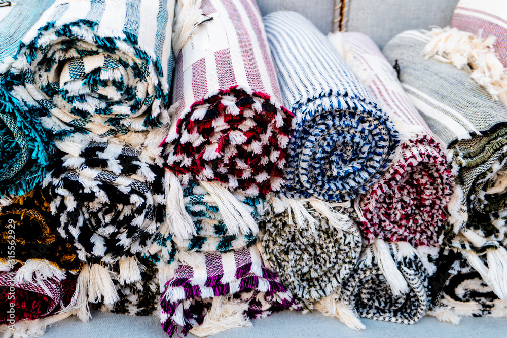 colorful cloth rugs rolled up in a Greek market colorful cloth rugs rolled up in a Greek market