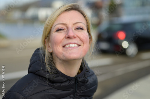 Cute young blond woman with an impish grin