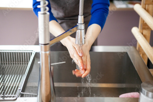 キッチンで手を洗う女性