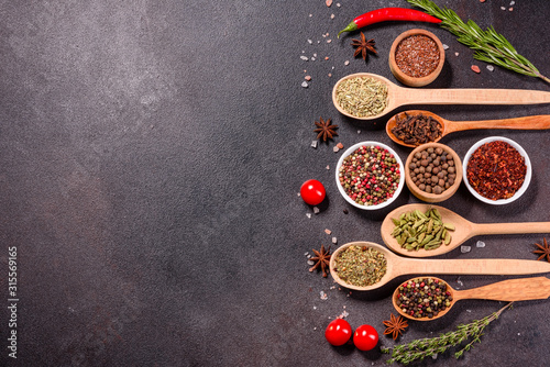 A set of spices and herbs. Indian cuisine. Pepper, salt, paprika, basil and other on a dark background © chernikovatv