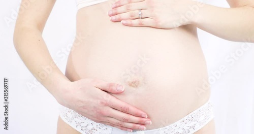 Wallpaper Mural Young pregnant woman caressing her tummy - White background Torontodigital.ca