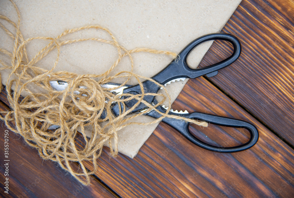 Tools for crafts on a wooden table top. Scissors, thread and paper. Tools for crafts on a wooden table top. Scissors, thread and paper.
