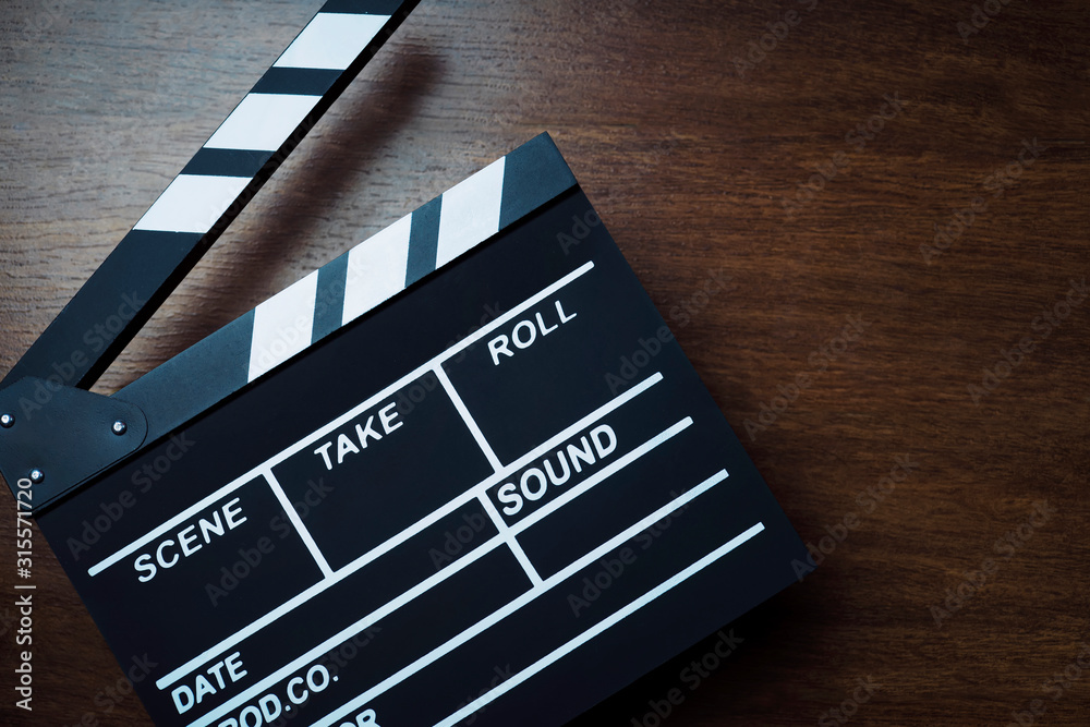 movie clapper cinema board or Slate film.Clapperboard for filmmaking and video production to assist in synchronizing of picture ,sound on Wooden Floor Tiles background.cinema concept