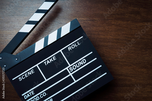 movie clapper cinema board or Slate film.Clapperboard for filmmaking and video production to assist in synchronizing of picture ,sound on Wooden Floor Tiles background.cinema concept photo