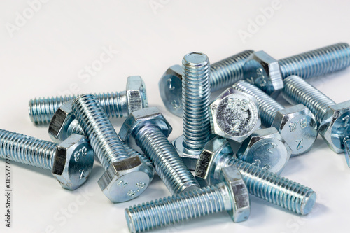 Metal chrome bolts with thread close-up on an isolated background. The tools for the job. Selective focus. Copy space, space for the label.