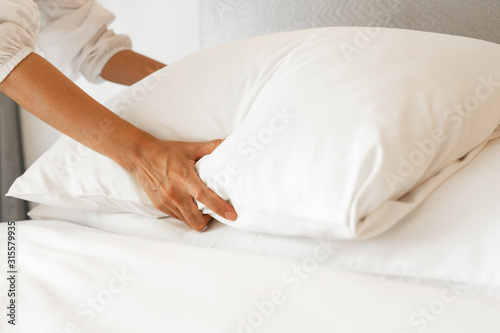 Female Hand set up white bed sheet in bedroom