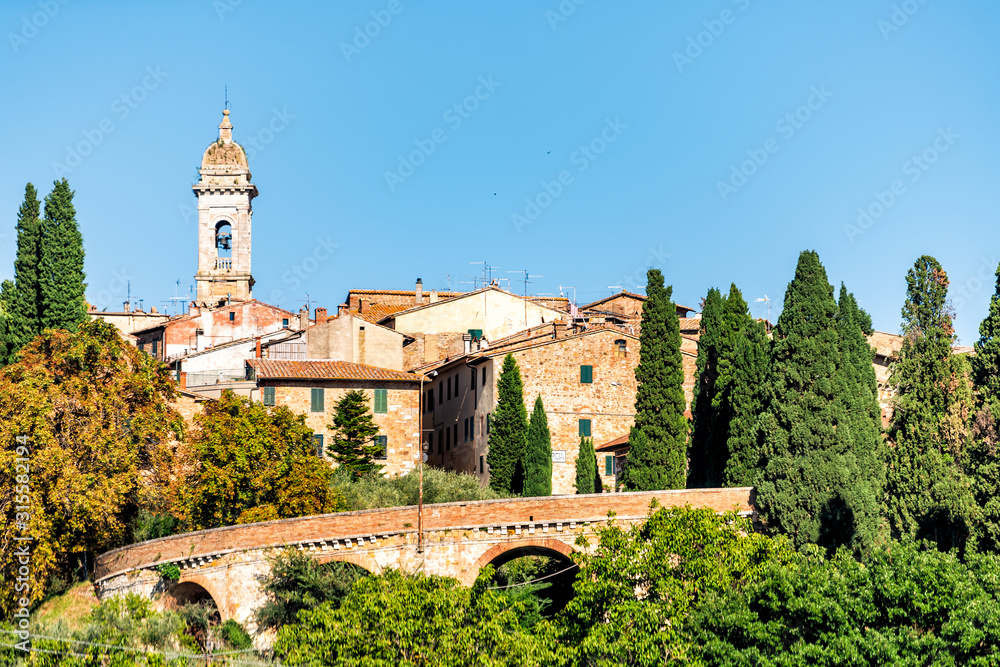 San Quirico D'Orcia, Italy town village city in Tuscany during sunny summer day and famous church bell tower view of cityscape and wall